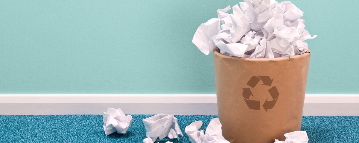 overflowing recycling bin with paper