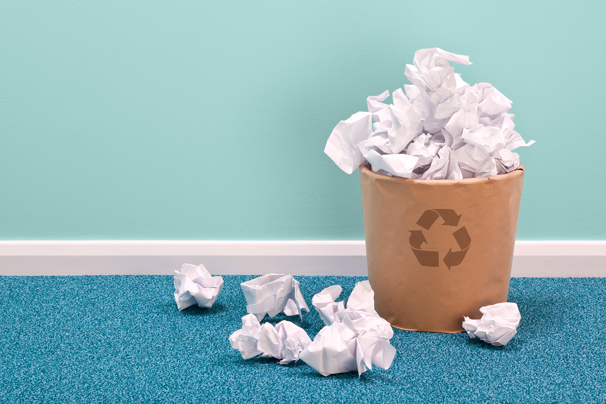 overflowing recycling bin with paper