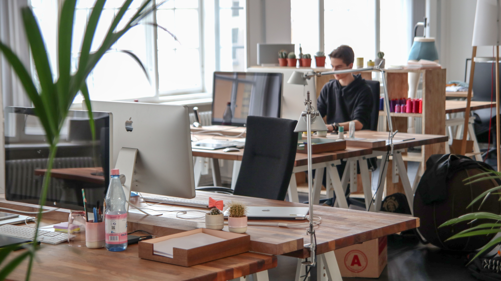 man sitting at a desk in an open workspace 